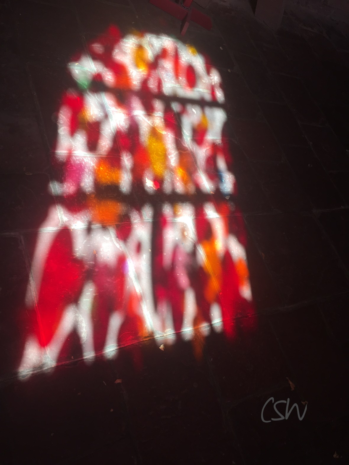 Church window reflections on a stone floor